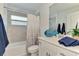 Fresh bathroom with neutral tiles, white vanity, sink, toilet and coordinated blue decor at 12470 Wellen Golf St # 208, Venice, FL 34293