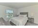 Cozy bedroom featuring a comfortable queen bed, neutral tones, and a window with a lovely view at 12470 Wellen Golf St # 208, Venice, FL 34293