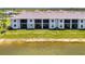 Beautiful condo building with a tile roof overlooking a pond with green space and landscaping at 12470 Wellen Golf St # 208, Venice, FL 34293