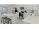 Well-lit kitchen featuring white cabinets, quartz countertops, stainless steel appliances and island at 12470 Wellen Golf St # 208, Venice, FL 34293