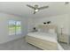 Calming main bedroom overlooking a pond and golf course with a ceiling fan and neutral decor at 12470 Wellen Golf St # 208, Venice, FL 34293