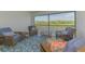 Screened patio with seating and view of pond and the golf course beyond at 12470 Wellen Golf St # 208, Venice, FL 34293