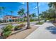 View of quaint shops and restaurants with a sidewalk, palm trees, and hanging flower baskets for a relaxed shopping experience at 12470 Wellen Golf St # 208, Venice, FL 34293