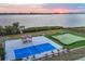Aerial view of backyard featuring waterfront view, boat dock, gazebo, pickleball court, and putting green at 1275 Bayshore Dr, Englewood, FL 34223