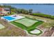 This backyard features a putting green, sand trap, pool, and tennis court with water access at 1275 Bayshore Dr, Englewood, FL 34223
