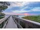 Scenic wooden walkway and boat dock overlooking tranquil waters at sunset at 1275 Bayshore Dr, Englewood, FL 34223
