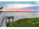 Scenic wooden walkway and boat dock overlooking tranquil waters at sunset at 1275 Bayshore Dr, Englewood, FL 34223