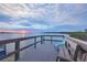 Wooden dock seating area features calm waters and sunset skies at 1275 Bayshore Dr, Englewood, FL 34223