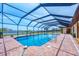 Beautiful screened-in pool with brick surround and serene water views for luxury outdoor living at 1275 Bayshore Dr, Englewood, FL 34223