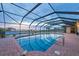 Screened pool area with brick pavers and distant water view at 1275 Bayshore Dr, Englewood, FL 34223