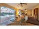Bright sunroom with wicker furniture, tile floors, and sliding doors leading to the pool at 1275 Bayshore Dr, Englewood, FL 34223