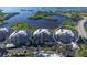 Stunning aerial view of waterfront condos, showcasing lush landscaping, bay views, and a resort-style pool at 13113 Gasparilla Rd # A503, Placida, FL 33946
