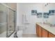 Bright bathroom featuring a glass enclosed shower, neutral vanity, and coastal-themed artwork at 13113 Gasparilla Rd # A503, Placida, FL 33946