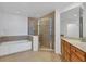 Bathroom featuring a soaking tub, glass enclosed shower, and vanity with granite counter at 13113 Gasparilla Rd # A503, Placida, FL 33946