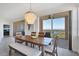 Elegant dining room featuring stylish chandelier, wood table, and sliding doors to the balcony at 13113 Gasparilla Rd # A503, Placida, FL 33946