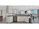 Bright kitchen with white cabinets, stainless dishwasher, and view of the water at 13113 Gasparilla Rd # A503, Placida, FL 33946