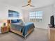 Bright main bedroom with blue bedding, wood furnishings, ceiling fan, and large window with a view at 13113 Gasparilla Rd # A503, Placida, FL 33946