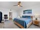 Bright main bedroom with blue bedding, wood furnishings, ceiling fan, desk, and television at 13113 Gasparilla Rd # A503, Placida, FL 33946