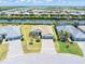 Waterfront home featuring a paver driveway, two car garage, and lush landscaping at 14556 Gaspar Loop, Port Charlotte, FL 33981