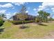 Inviting backyard features lush lawn, trimmed hedges, and a screened-in lanai for comfortable outdoor living at 14556 Gaspar Loop, Port Charlotte, FL 33981