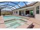View of a manicured backyard with an in-ground pool and lush foliage surrounding the enclosure at 14556 Gaspar Loop, Port Charlotte, FL 33981