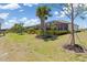 Landscaped backyard with tropical trees features an enclosed pool patio at 14556 Gaspar Loop, Port Charlotte, FL 33981