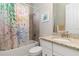 Bright bathroom featuring granite countertop vanity and a shower and tub with colorful curtain at 14556 Gaspar Loop, Port Charlotte, FL 33981