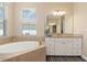 Bathroom with soaking tub, granite countertop, a vanity, and natural light at 14556 Gaspar Loop, Port Charlotte, FL 33981