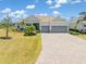 Beautiful one-story home with a three-car garage, well-manicured lawn and a paver driveway at 14556 Gaspar Loop, Port Charlotte, FL 33981