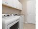 Well-equipped laundry room with modern washer and dryer, countertop and ample storage space at 14556 Gaspar Loop, Port Charlotte, FL 33981