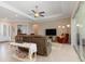 Spacious living room with neutral paint, tile floors, fan, and sliding glass doors at 14556 Gaspar Loop, Port Charlotte, FL 33981