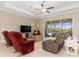 Cozy living room with tile flooring, comfortable seating, and sliding glass doors to the lanai at 14556 Gaspar Loop, Port Charlotte, FL 33981