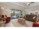 Bright living room offering tile flooring, fan, sliding glass doors, and backyard access at 14556 Gaspar Loop, Port Charlotte, FL 33981