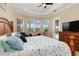 Well-lit main bedroom featuring tray ceilings, tiled floors, large windows, and pool access at 14556 Gaspar Loop, Port Charlotte, FL 33981