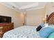 Serene main bedroom with tray ceilings, a TV, and a large comfortable bed with decorative pillows at 14556 Gaspar Loop, Port Charlotte, FL 33981