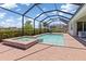Beautiful pool with a spa surrounded by brick pavers inside of a screened enclosure at 14556 Gaspar Loop, Port Charlotte, FL 33981
