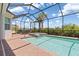 Screened pool with attached spa and brick paver decking, surrounded by manicured landscaping at 14556 Gaspar Loop, Port Charlotte, FL 33981