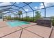 The backyard features an in-ground pool with an outdoor kitchen, and lush landscaping at 14556 Gaspar Loop, Port Charlotte, FL 33981