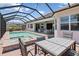 Inviting screened-in pool with spa, patio seating, and views of the home's exterior at 14556 Gaspar Loop, Port Charlotte, FL 33981