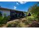 Enclosed patio overlooks a private backyard with lush, mature landscaping and a variety of potted plants at 148 Jose Gaspar Dr # 148, Englewood, FL 34223