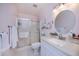Bright bathroom featuring a shower with sliding doors, a white vanity, and tile flooring for easy maintenance at 148 Jose Gaspar Dr # 148, Englewood, FL 34223