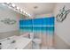 Bright bathroom featuring a ocean theme curtain, white tile, and a decorative fish wall decoration at 148 Jose Gaspar Dr # 148, Englewood, FL 34223