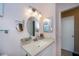 Bathroom featuring a sleek vanity with a round mirror, modern lighting, and ample counter space at 148 Jose Gaspar Dr # 148, Englewood, FL 34223