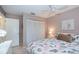 Bright bedroom with seashell-themed bedding, closet, and a modern white nightstand on tile flooring at 148 Jose Gaspar Dr # 148, Englewood, FL 34223
