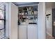 Laundry area with washer, dryer, and shelving for storage behind closet doors at 148 Jose Gaspar Dr # 148, Englewood, FL 34223