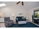 Cozy living room with vaulted ceiling, blue sofa and armchair, and sliding door access to the outdoors at 148 Jose Gaspar Dr # 148, Englewood, FL 34223
