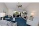 Bright living room features a ceiling fan, TV, comfortable seating, and screened lanai access at 148 Jose Gaspar Dr # 148, Englewood, FL 34223
