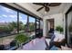 Comfortable screened patio with view of the backyard featuring lots of plants and a ceiling fan at 148 Jose Gaspar Dr # 148, Englewood, FL 34223