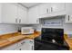 Bright kitchen features white cabinets, butcher block counters, and modern appliances at 1531 Placida Rd # 201, Englewood, FL 34223