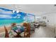 Open-concept living and dining area with beach-themed decor and ample seating at 1531 Placida Rd # 201, Englewood, FL 34223